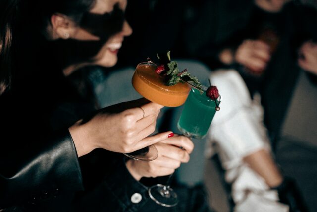 hands holding colourful cocktails