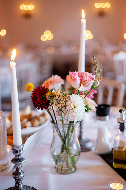 Shabbat candles on a table with spring flowers in a vase